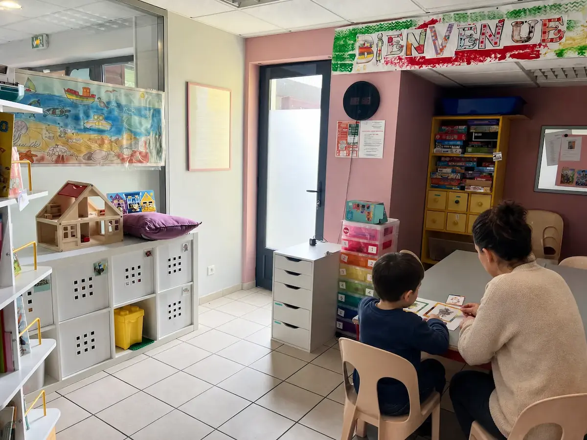 Enfant participant à une activité pédagogique avec une professionnelle du DAPAS