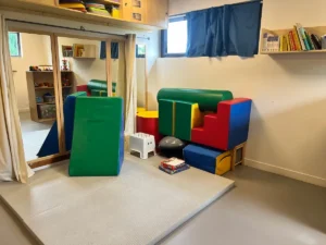 Salle de motricité du DAPAS avec modules en mousse et miroir