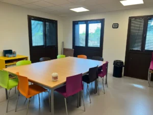 Grande table et chaises dans la salle de travail collectif du DIAPS